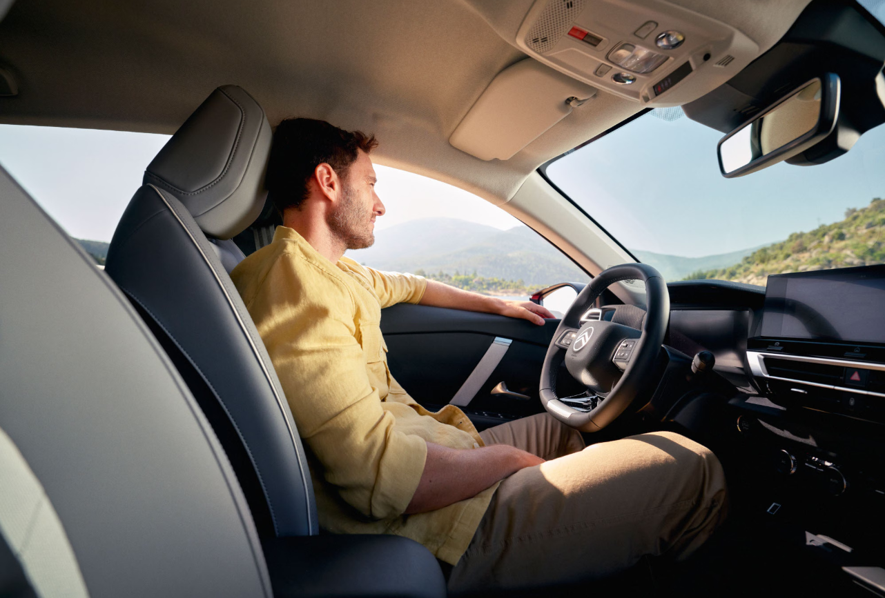 Interieur van de Citroën C4 met ruime achterbank, glazen zonnedak en tablethouder in het dashboard.