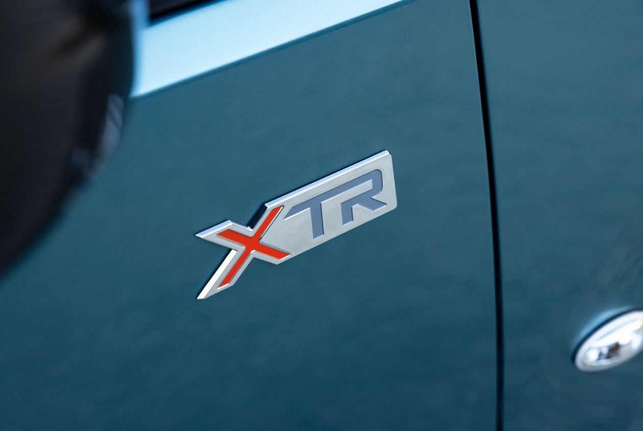 Zijaanzicht van de Citroën Berlingo XTR, geparkeerd buiten, met het XTR-logo zichtbaar op de carrosserie en de typische styling van het model.