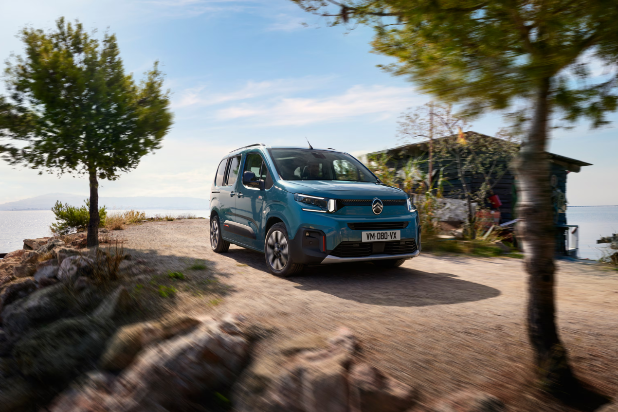Zijaanzicht van de Citroën Berlingo, geparkeerd op straat, met zicht op de portieren, ramen en wielen.
