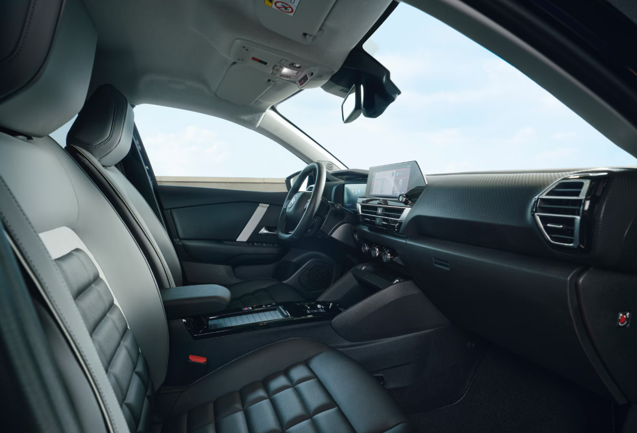 Interieur van de Citroën ë-C4, met dashboard, multifunctioneel stuur, touchscreen en comfortabele stoelen zichtbaar.
