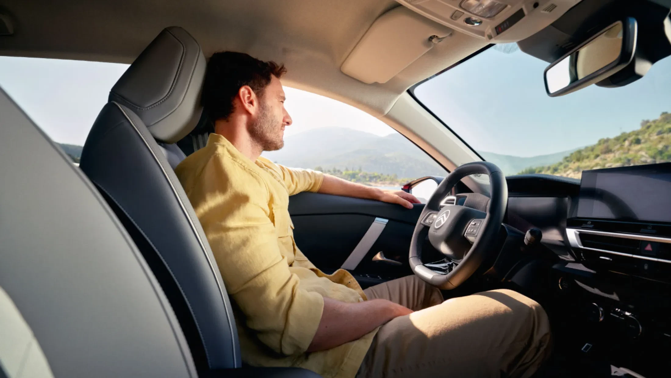 Interieur van de Citroën C4 met ruime achterbank, glazen zonnedak en tablethouder in het dashboard.