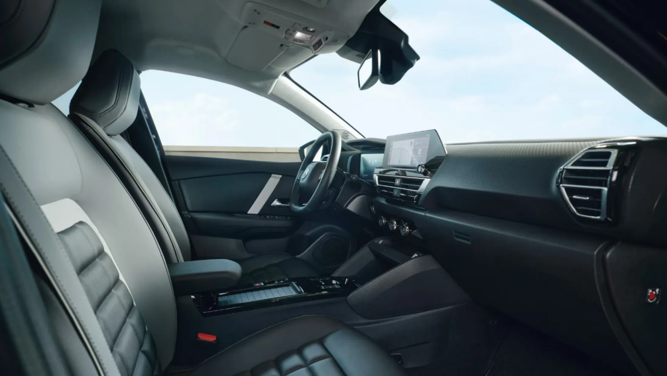 Interieur van de Citroën ë-C4, met dashboard, multifunctioneel stuur, touchscreen en comfortabele stoelen zichtbaar.